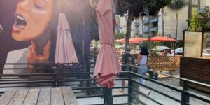 cafe outdoor pathway pavement pedestrian sidewalk street umbrellas urban walkway